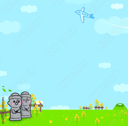 Peaceful rapeseed field in Jeju Island. A couple of Dolhareubang (traditional stone statues in Jeju Island, Korea) are smiling happily.