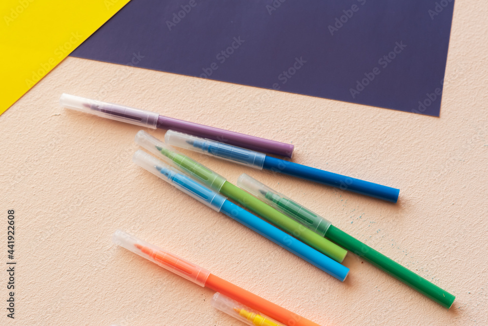 A set for children's creativity and development. felt-tip pens, colored paper on the table. A set for children's creativity and development. felt-tip pens, colored paper on the table.