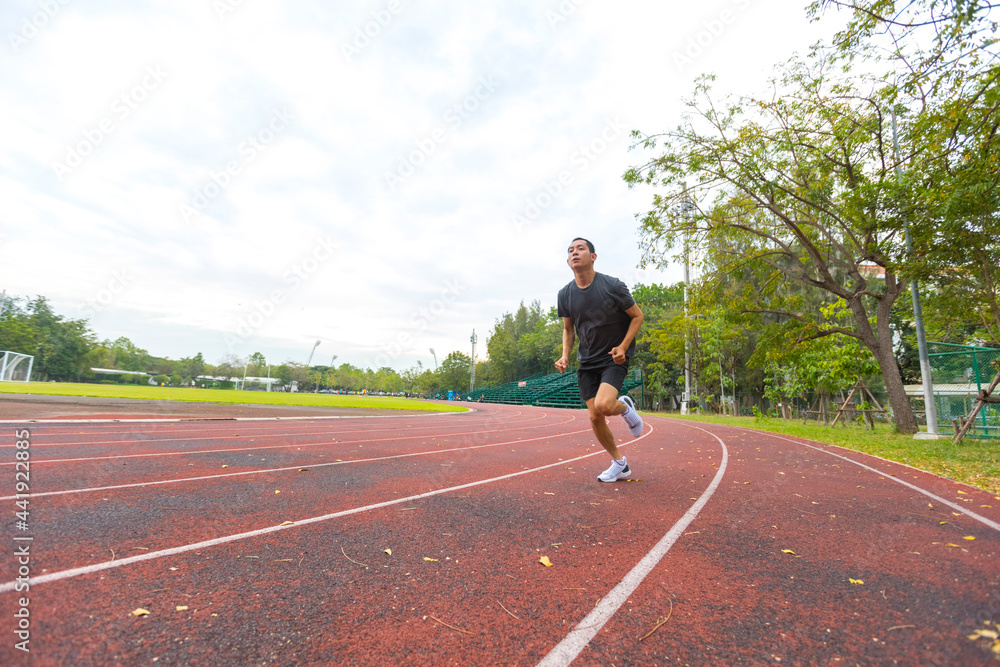 young Asian man athlete running and training on the running track. young Asian man athlete running and training on the running track.