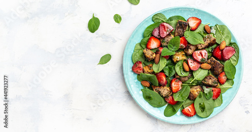 Fresh strawberries, spinach salad with chicken liver, almond and mint. Healthy fats, clean eating for weight loss. Long banner format. top view