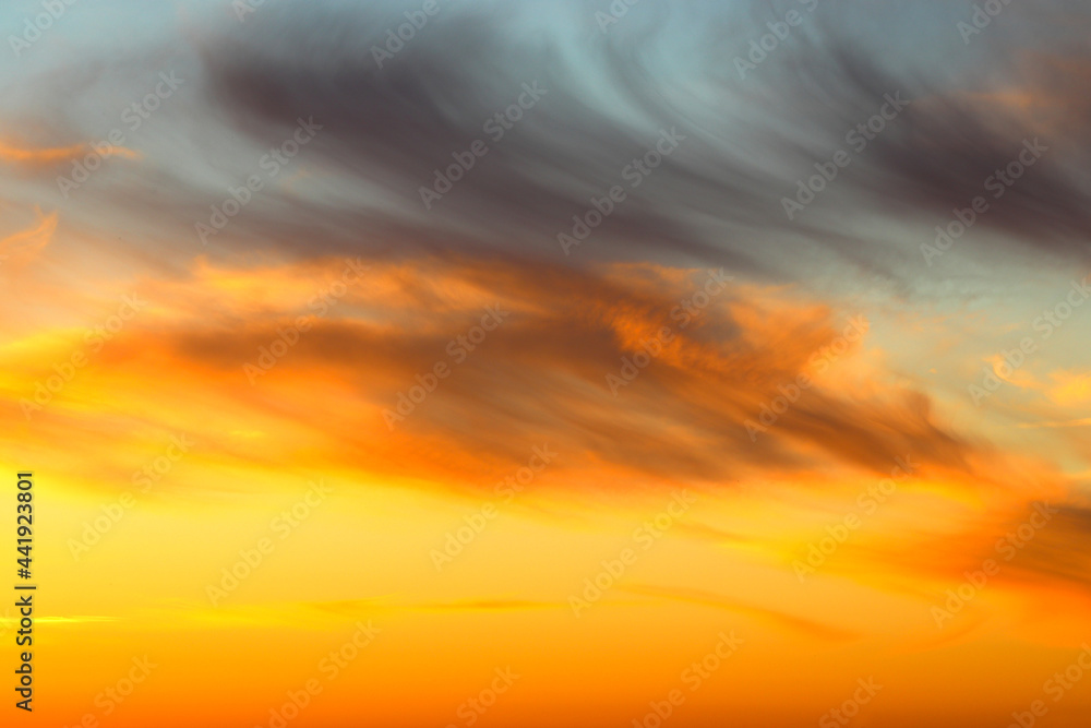 Cirrus clouds orange on the sunset, evening sky