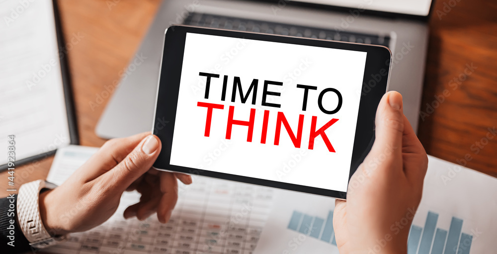 Man hands holding tablet with text TIME TO THINK at workplace. Businessman working at desk with documents Man hands holding tablet with text TIME TO THINK at workplace. Businessman working at desk with documents