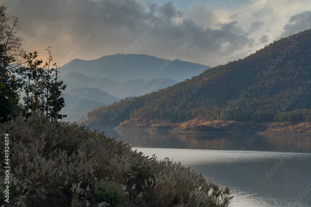 Complexity of mountain landscape and reservoir  with beautiful cloudy sky in background