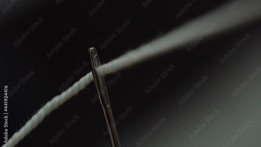 Closeup shot of a thread that is threaded through the eye of a needle
Closeup shot of a thread that is threaded through the eye of a needle