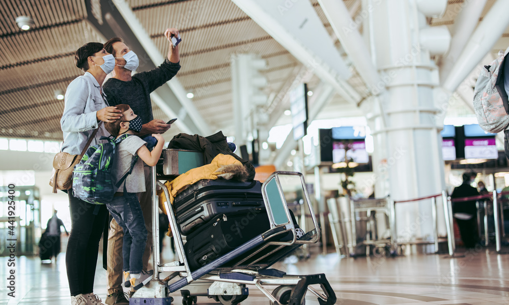 Obraz premium Family checking their flight timing at airport terminal
