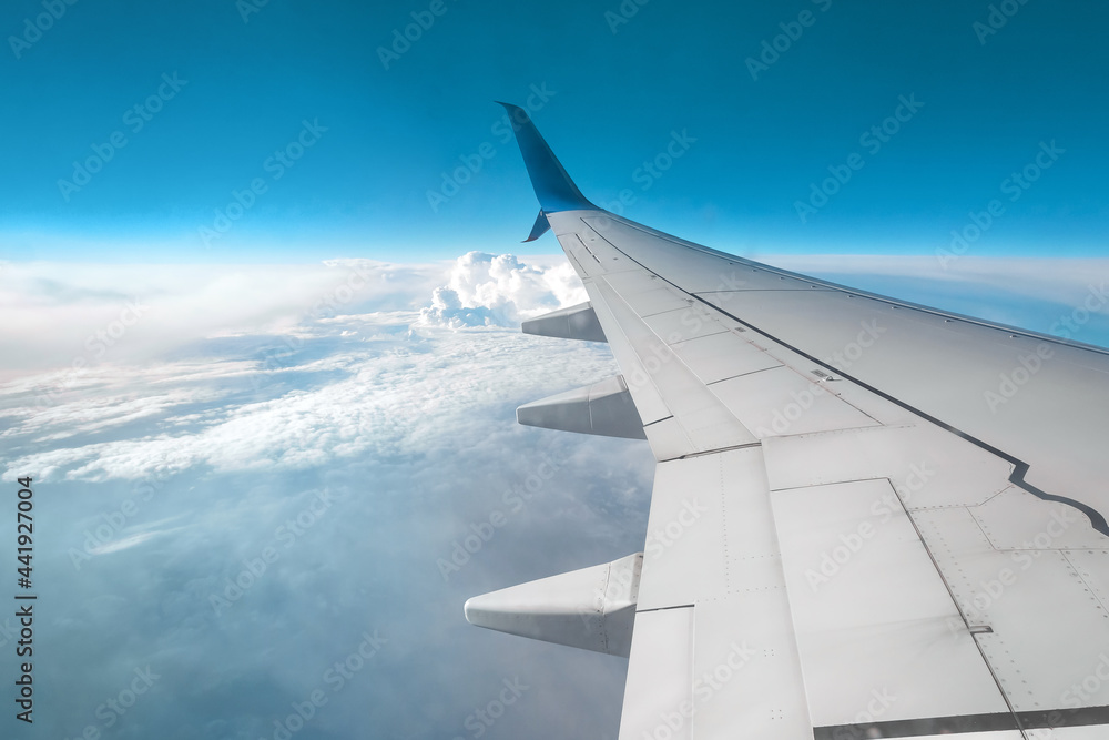 View from the window of a passenger plane above the clouds. International cargo transportation, air travel, transport, air travel, vacations. Copy space.