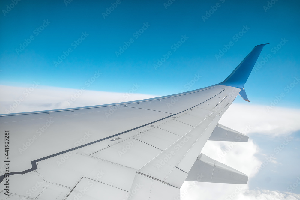 View from the window of a passenger plane above the clouds. International cargo transportation, air travel, transport, air travel, vacations. Copy space.