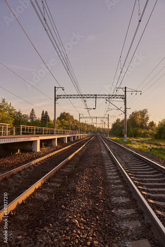 Industrial landscape with rails and railway on sunset.