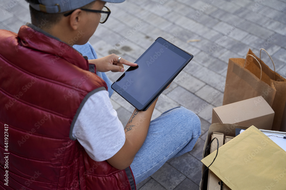 Obraz premium Checking adress of a client. Male courier looking at map or usin