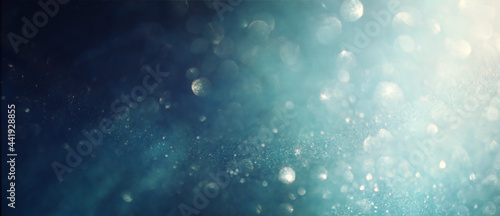 background of abstract glitter lights. gold, blue and black. de focused