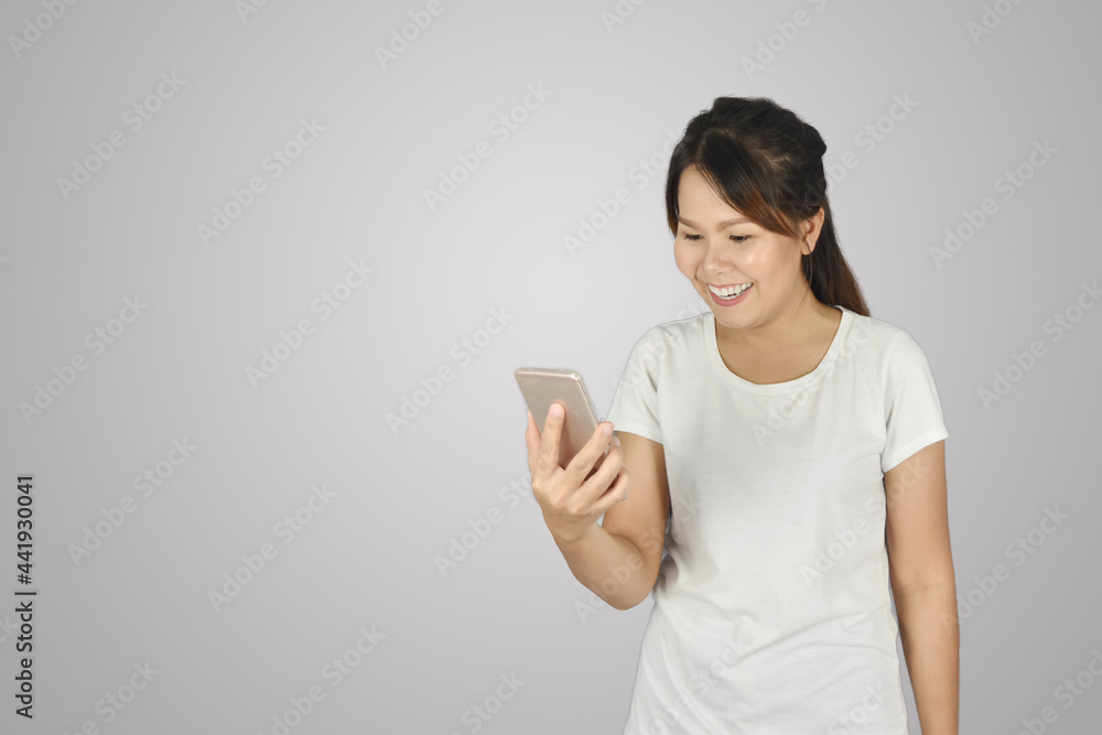 attractive and smiling women in t-shirts holding smartphones and showing happy gesture attractive and smiling women in t-shirts holding smartphones and showing happy gesture