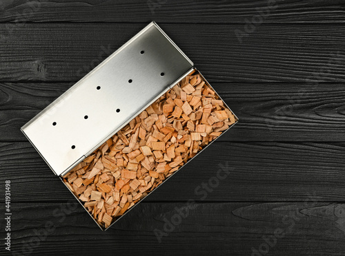 Φωτογραφία Metal smoker box with wood chips on table