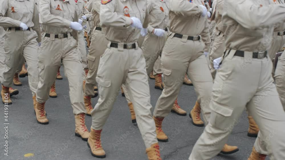 Young soldiers in brown army uniforms and white gloves march in a parade or demonstration. Young soldiers in brown army uniforms and white gloves march in a parade or demonstration.