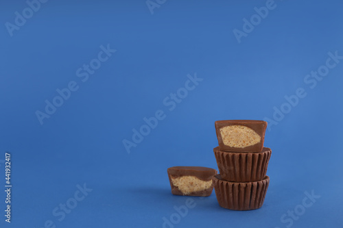 Sweet peanut butter cups on blue background. Space for text