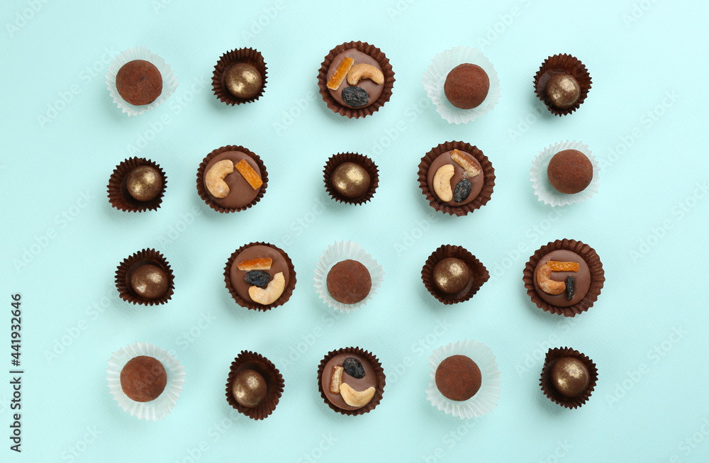 Different delicious chocolate candies on light blue background, flat lay Different delicious chocolate candies on light blue background, flat lay