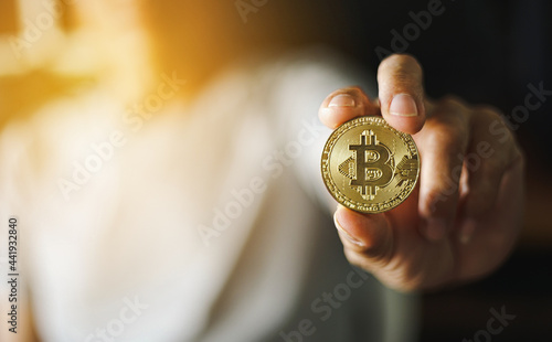 Man hand holding Gold Bitcoin Coin, cryptocurrency concept. 