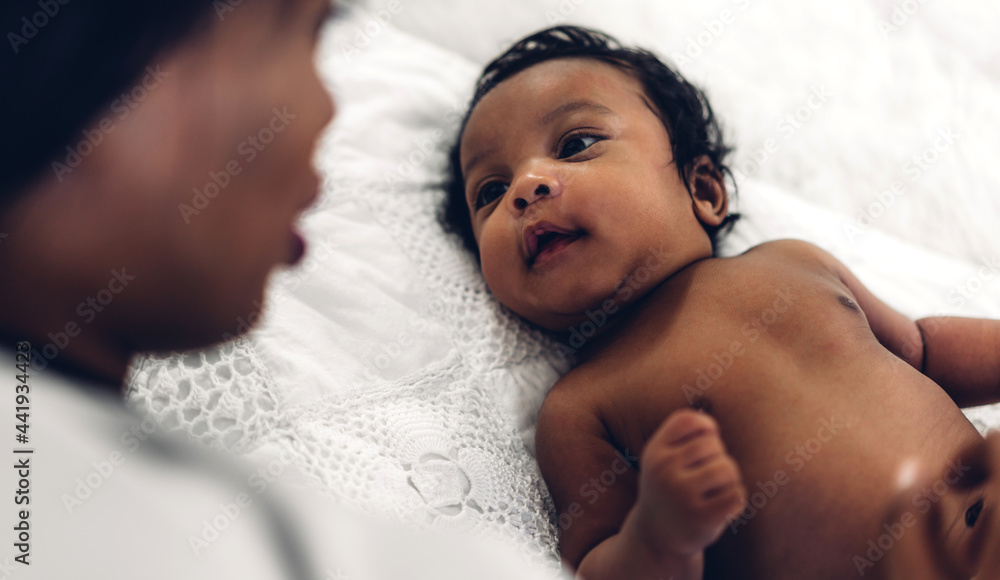 Portrait of enjoy happy love family african american mother playing with adorable little african american baby.Mom touching with cute son moments good time in a white bedroom.Love of black family Portrait of enjoy happy love family african american mother playing with adorable little african american baby.Mom touching with cute son moments good time in a white bedroom.Love of black family