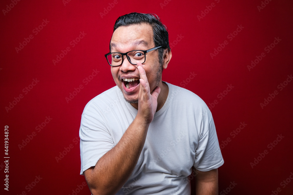 Young handsome man with hand on mouth telling secret rumor, whispering malicious talk conversation Young handsome man with hand on mouth telling secret rumor, whispering malicious talk conversation