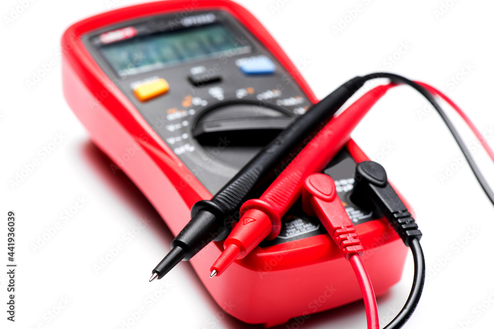 Electronic digital multimeter isolated on white with probes. Digital multimeter with red and black leads. Electronic multimeter isolated on white background close up Electronic digital multimeter isolated on white with probes. Digital multimeter with red and black leads. Electronic multimeter isolated on white background close up