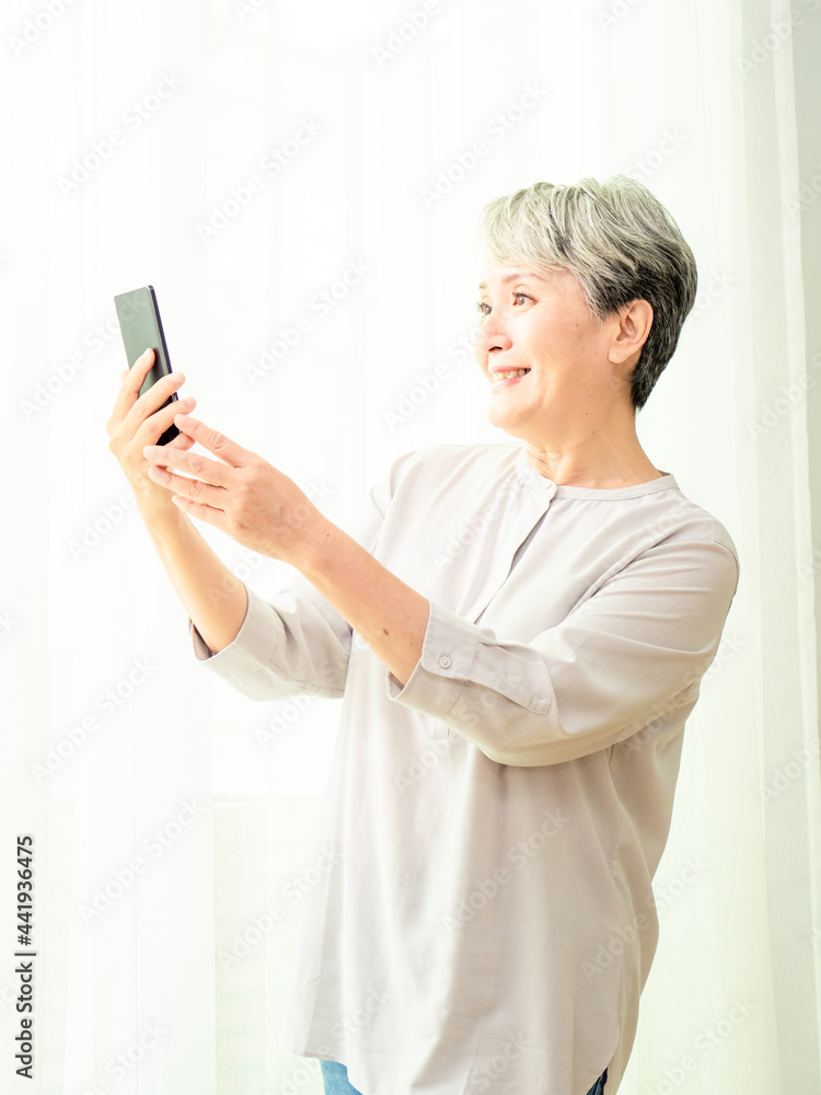 Senior asian woman using or talking on her mobile phone. Senior asian woman using or talking on her mobile phone.
