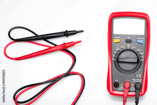 Electronic digital multimeter isolated on white with probes. Digital multimeter with red and black leads. Electronic multimeter isolated on white background close up