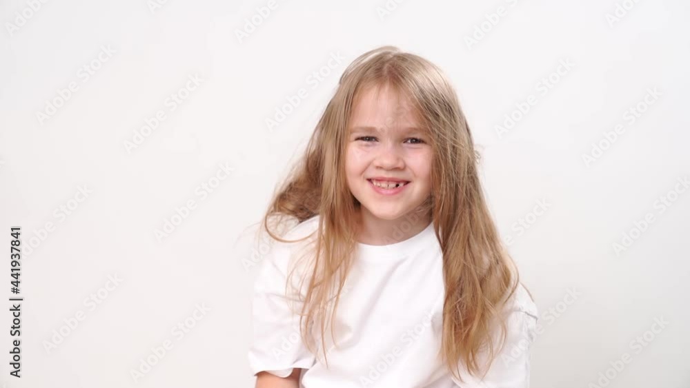 Funny little girl with dishevelled hair smiles against a white background. Place for the inscription. happy childhood. Psychological and medical care for children Funny little girl with dishevelled hair smiles against a white background. Place for the inscription. happy childhood. Psychological and medical care for children