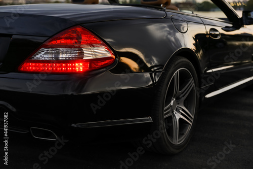Luxury black convertible car outdoors in evening, closeup © New Africa
