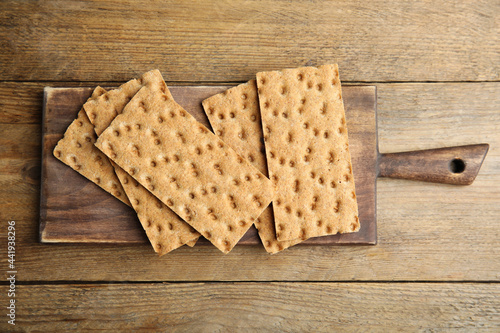 Tableau sur toile Board with fresh rye crispbreads on wooden table, top view