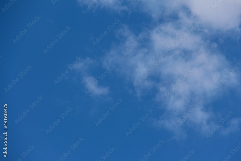 Beautiful blue sky with fluffy clouds. The concept of dreaminess and lightness. Meteorology and atmospheric phenomena. Different types of clouds. Layered clouds.