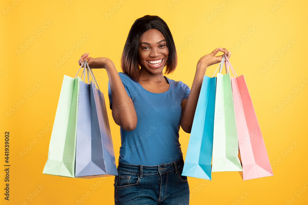 Joyful African American Woman Holding Colorful Shopper Bags, Yellow Background