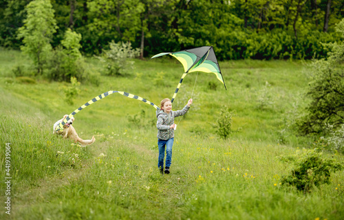 Smiling little girl playing with kite
