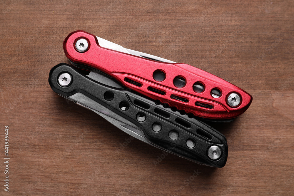 Modern compact portable multitool on wooden table, top view Modern compact portable multitool on wooden table, top view