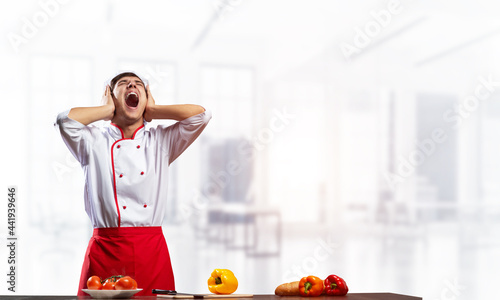 Young male chef screaming in shock and horror