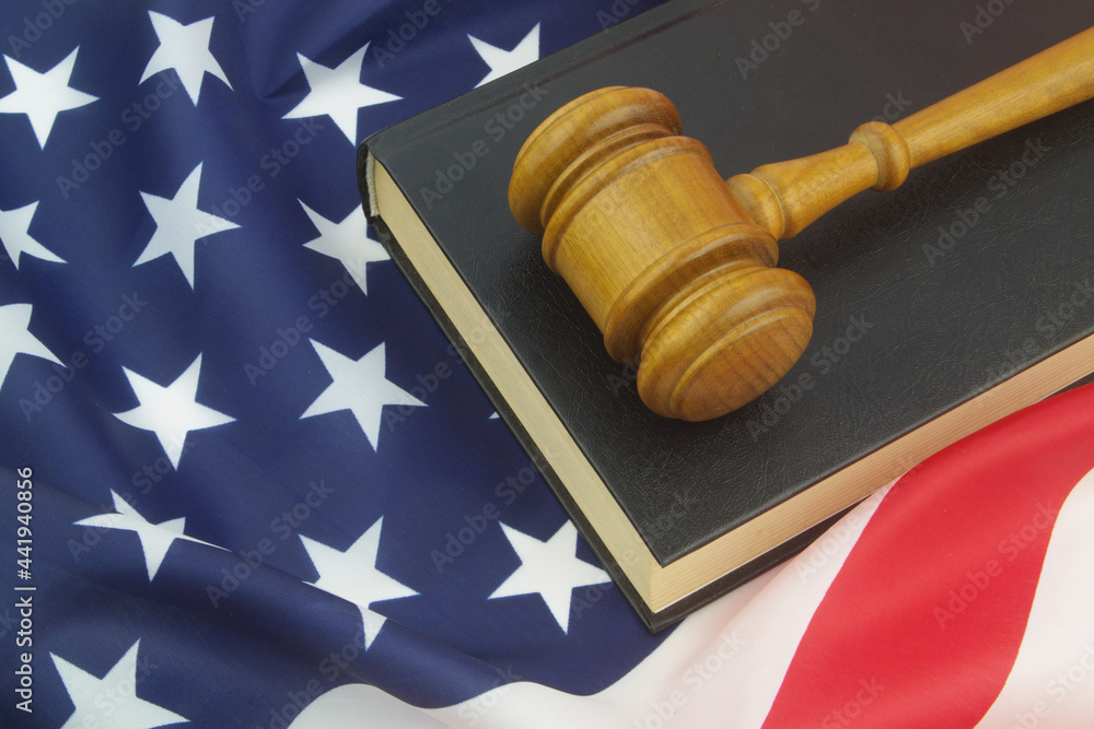 Legal book and judge gavel on USA flag. Laws and court of United States concept.