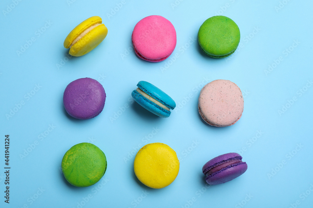 Delicious colorful macarons on light blue background, flat lay Delicious colorful macarons on light blue background, flat lay