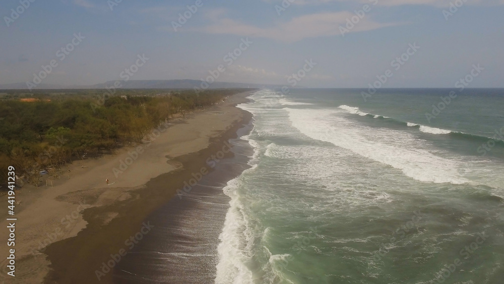 aerial view sandy beach near ocean with big waves at sunset time in tropical resort, Yogyakarta, Indonesia. seascape, ocean and beautiful beach. Travel concept. Indonesia, java