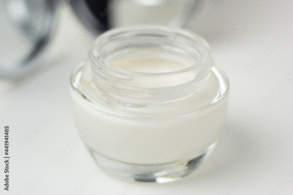 Closeup of a pampering skincare set – moisturizer in a glass jar and a mirror. Closeup of a pampering skincare set – moisturizer in a glass jar and a mirror.