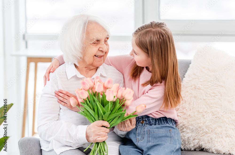 Grandaughter gives flowers to grandmother Grandaughter gives flowers to grandmother