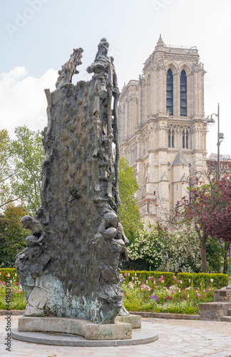 Paris, France - 05 02 2021: View of Notre-Dame from Square Rene Viviani and stele in memory of the young Jewish children of the 5th arrondissement who died in deportation during the Second World War photo