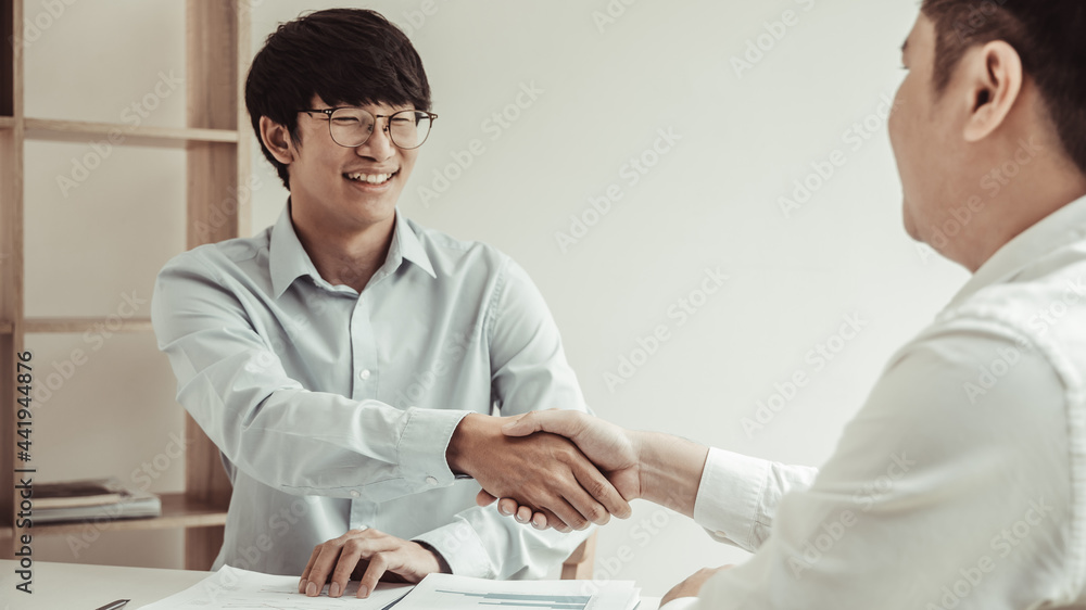 Obraz premium Business personage handshake, Asian business women congratulate on being a corporate partnership with European man investors, Friendship, Sign language greetings, Successful business negotiations.