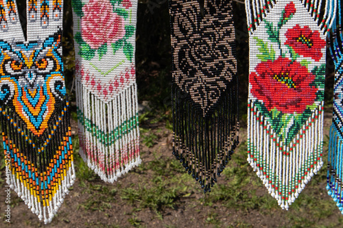 Quadro em tela Few different bright beaded decorative pendants at the open air fair