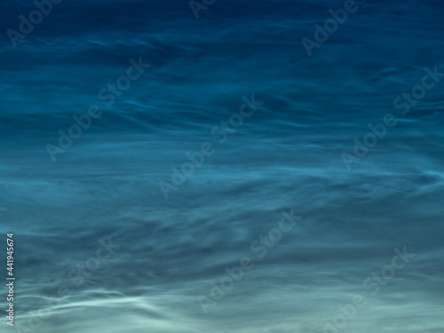 Starry sky with noctilucent clouds at summer solstice night. Fantastic cloudscape. Natural pattern, texture, background, wallpaper, graphic resources, design, abstract art, copy space.