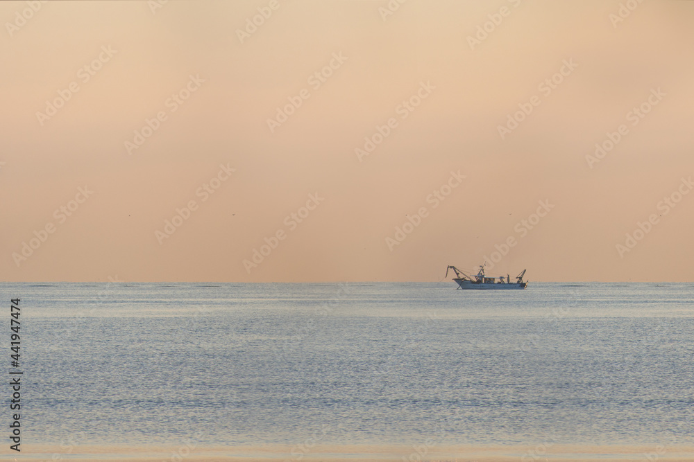 fishing boat at dawn at sea
