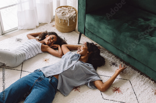 African woman with daughter lying on carpet