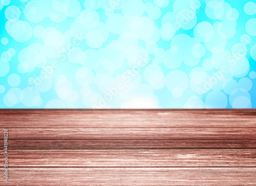 Empty wooden table with blue background and bokeh.