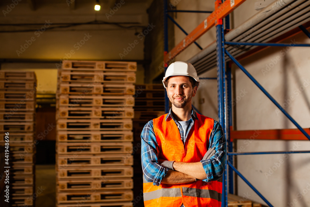 The worker in uniform is standing near the shelves The worker in uniform is standing near the shelves