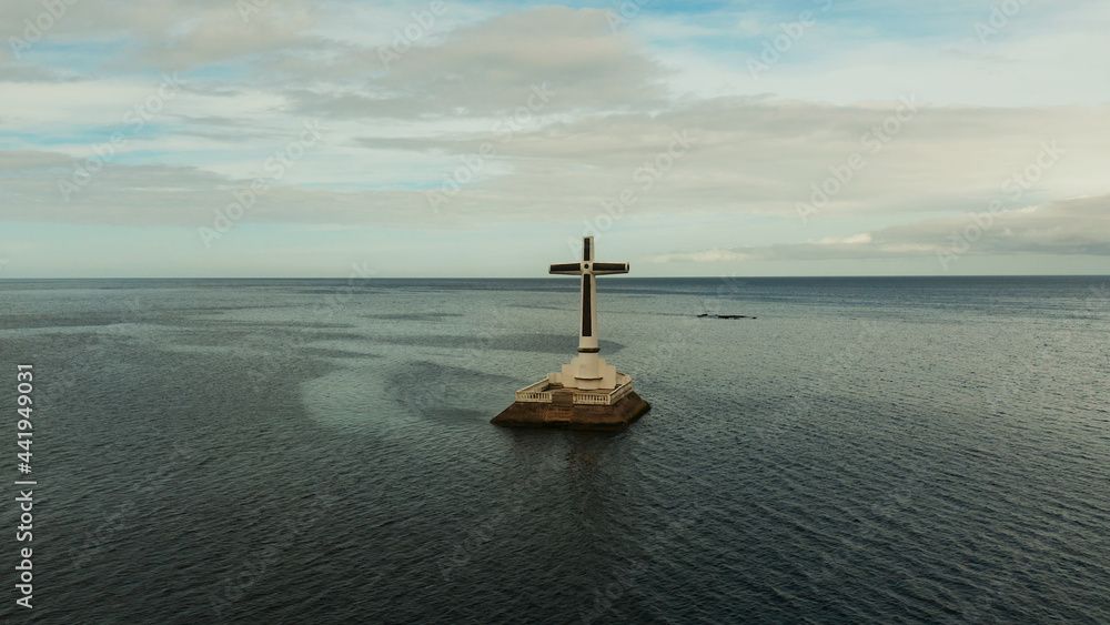 Catholic cross in sunken cemetery in the sea at sunset, aerial view. Sunset at Sunken Cemetery Camiguin Island Philippines.