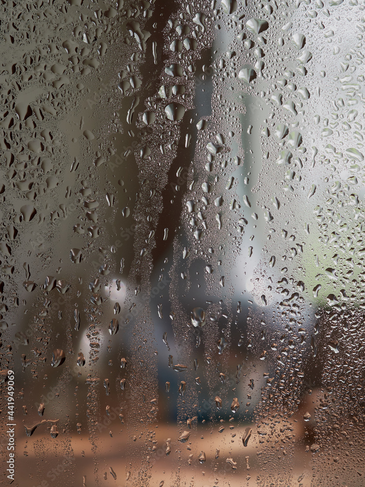 Rain drops on window glasses surface with sunset. drops on glass spray on window background for dark text selective focus