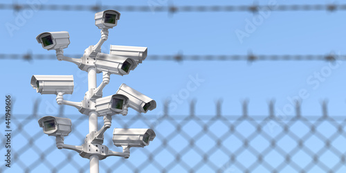 CCTV secutity cameras system and barbed wire fence. Privacy, security and protection concept.