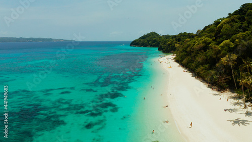 Sandy beach and turquoise water in the tropical resort of Boracay, Puka shell beach, Philippines aerial view. White beach with tourists. Summer and travel vacation concept.